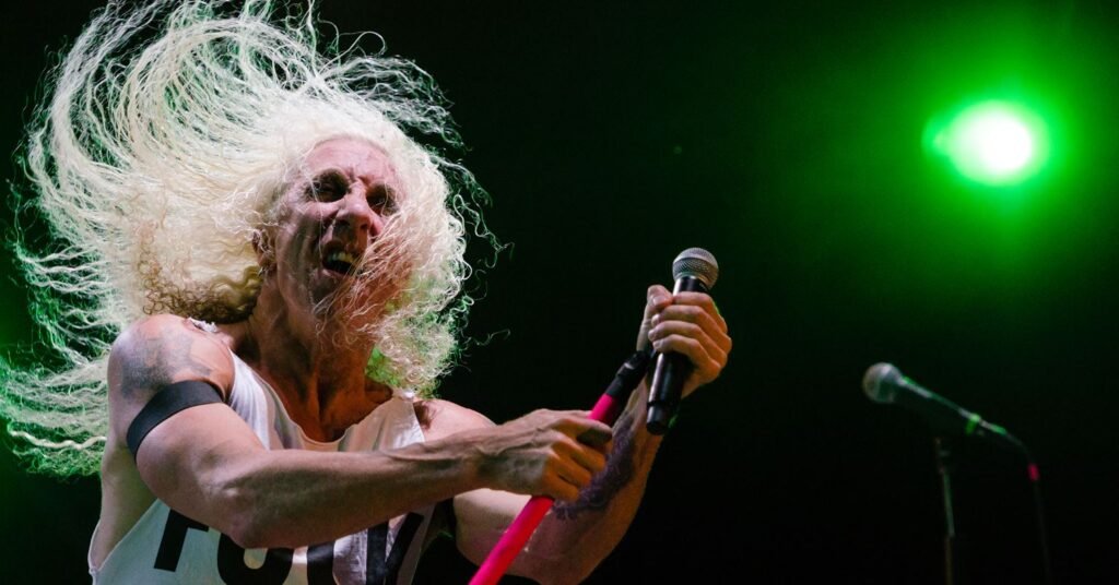 Dee Snider durante uma apresentação do Twisted Sister, imagem refletindo a energia do rock e a importância da saúde do artista.