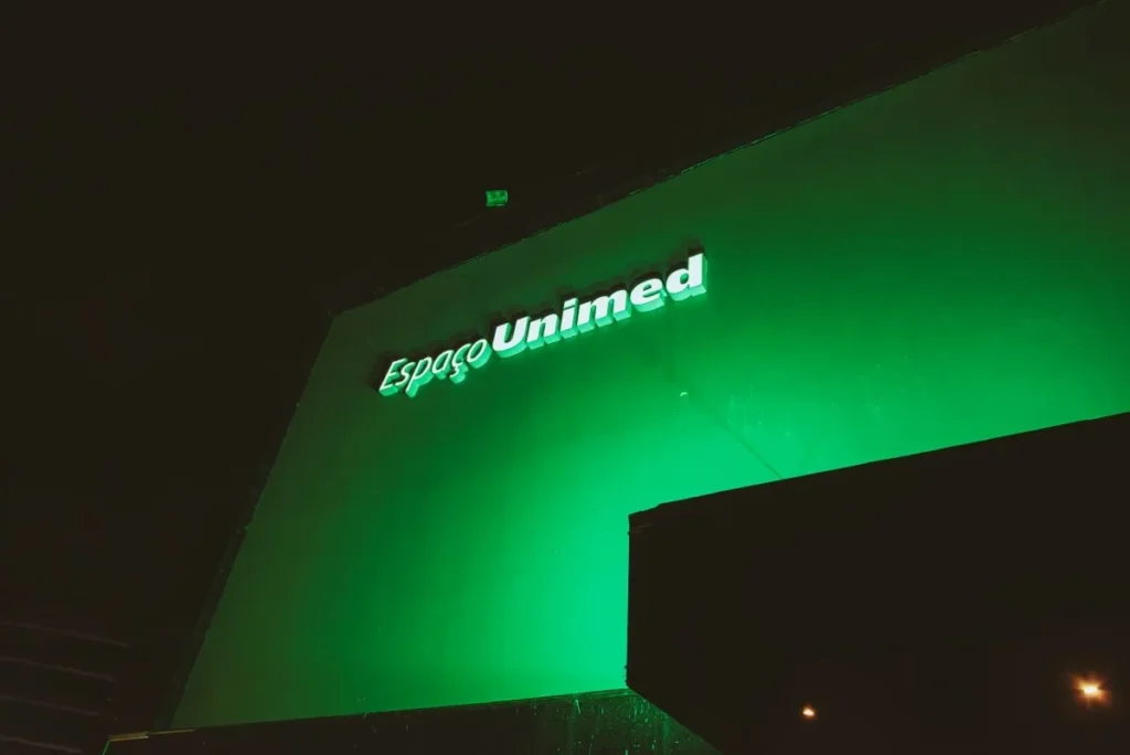 Fachada externa Espaço Unimed em São Paulo durante um show lotado em 2026, com palco iluminado e público vibrante.