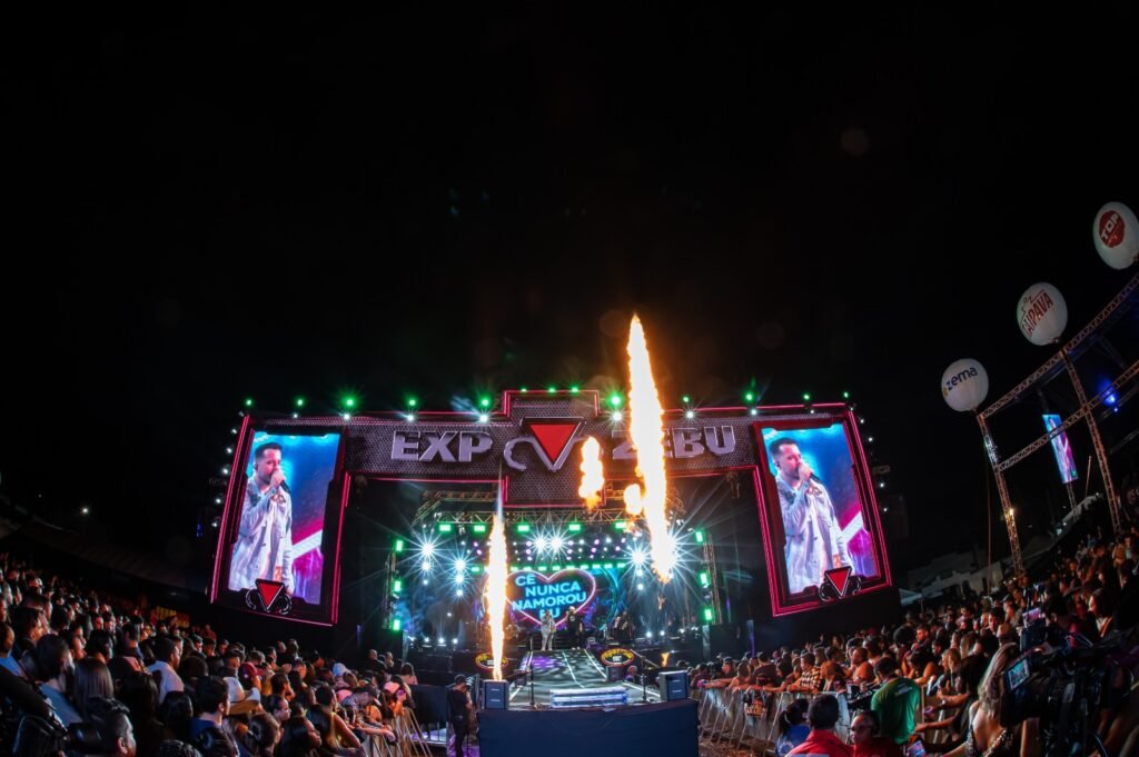 Público animado no Expozebu Rodeo Show em Uberaba, MG, com shows de sertanejo e competições de rodeio.