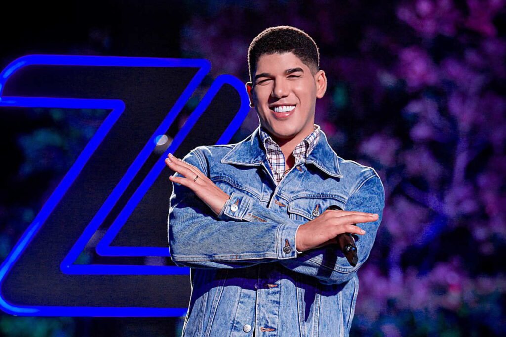 Zé Vaqueiro cantando no palco durante um show de piseiro em 2026, com chapéu característico e iluminação vibrante.