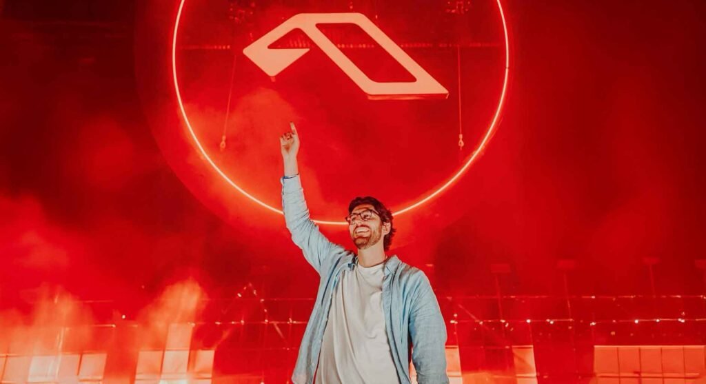 Público desfrutando do Anjunadeep Open Air em São Paulo, com a Varanda Estaiada ao fundo e artistas se apresentando.