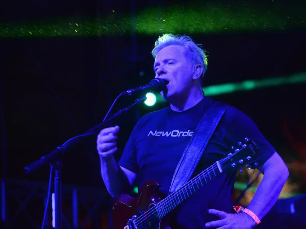Show da banda New Order em São Paulo, com público animado e iluminação no palco